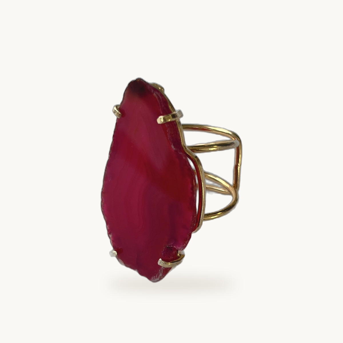 Bague Ágata ORA, large tranche d'agate fuchsia sertie griffes sur anneau plaqué or ajustable, fond beige