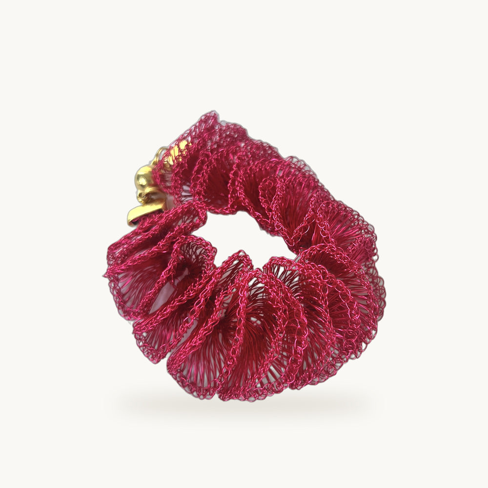 Bracelet Orquídea ORA, corolle de volants en fil métallique rose fuchsia travaillés à la main, fermoir doré, fond beige