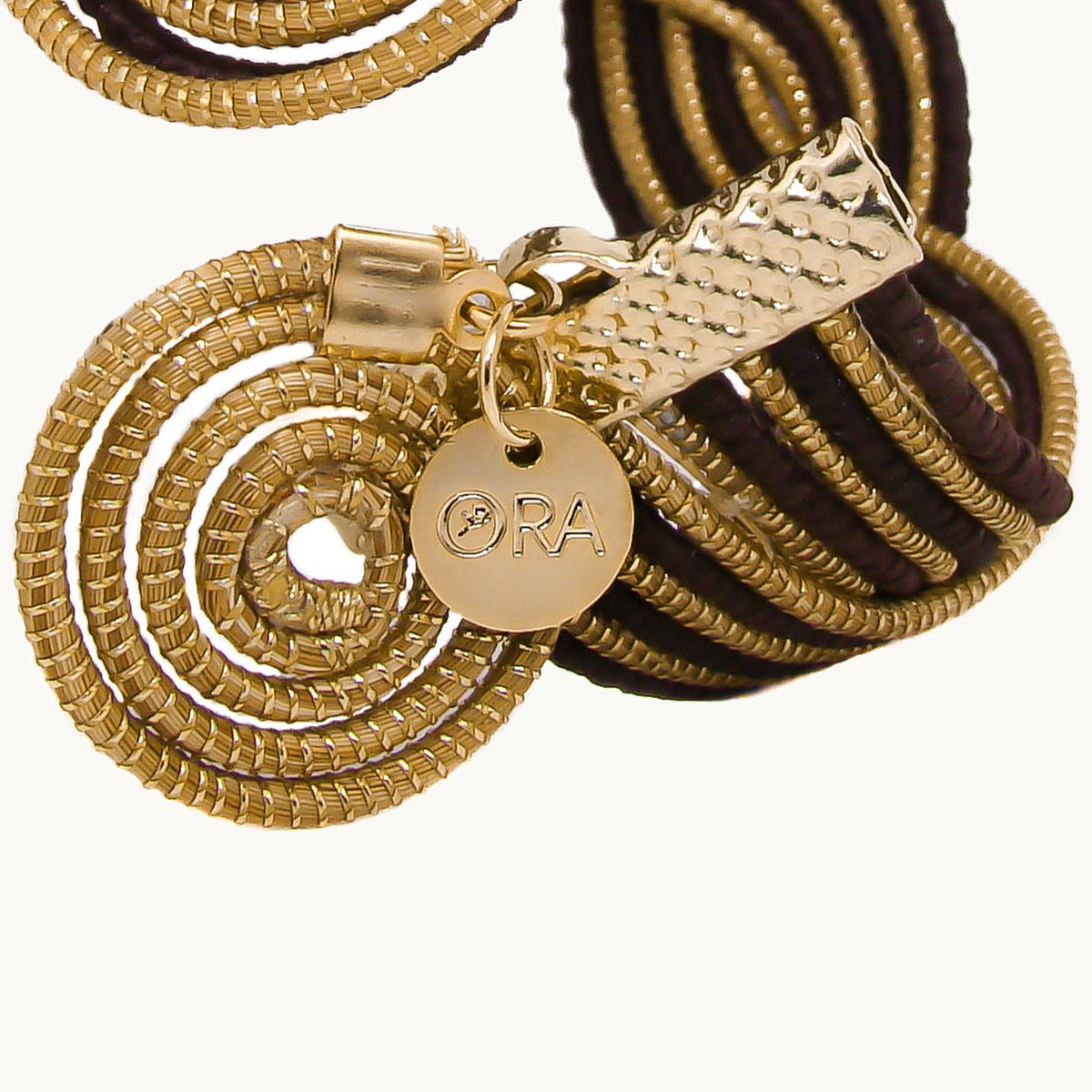 Détail du fermoir en spirale et de la médaille ORA de la manchette Caracol