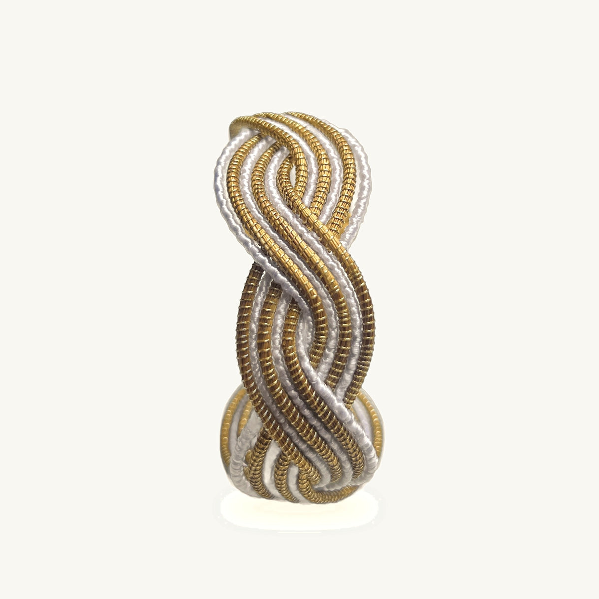 Manchette Caracol ORA alternée blanche, capim dourado tressé main en nœud infini, fond beige