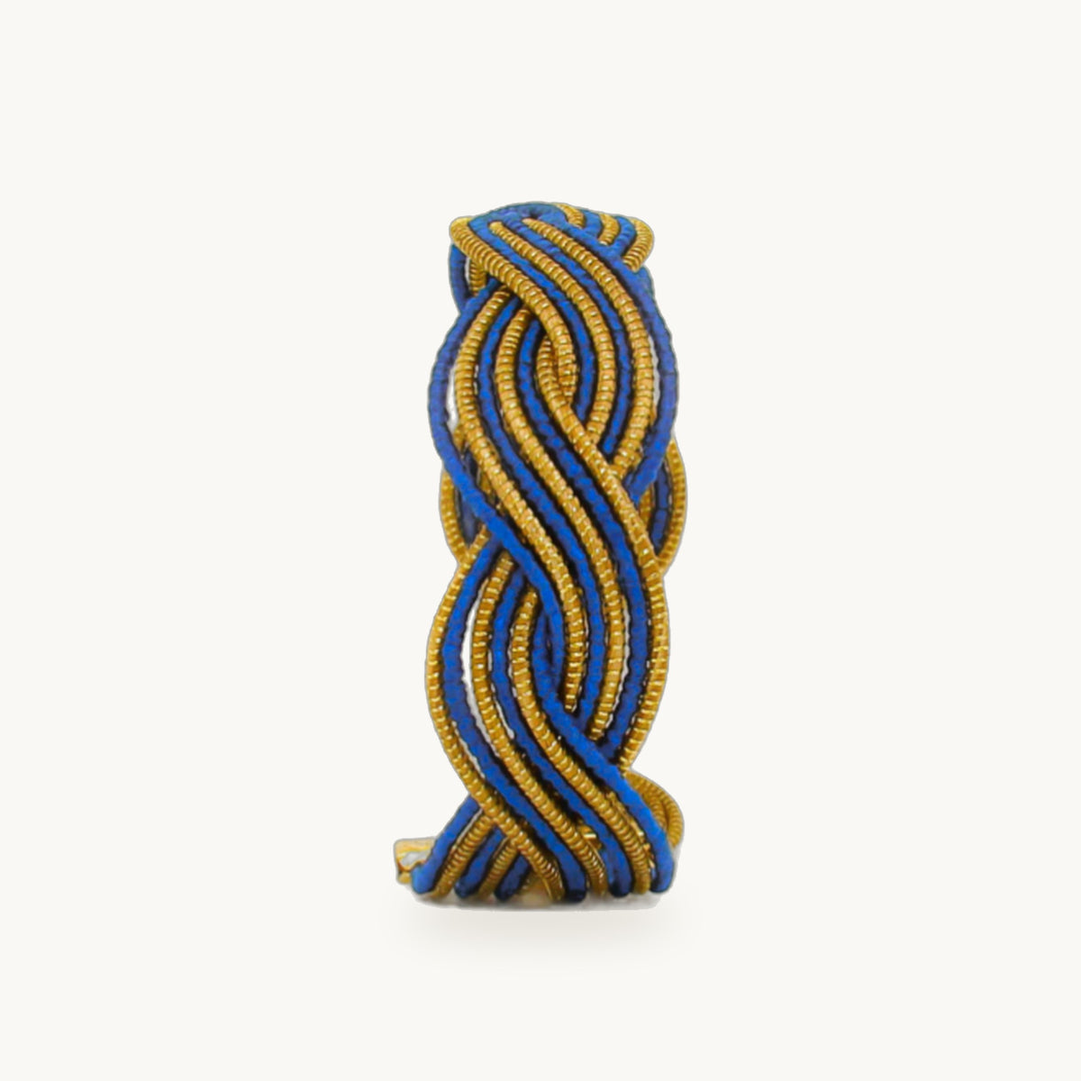 Manchette Caracol ORA alternée bleu roi, capim dourado tressé main en nœud infini, fond beige