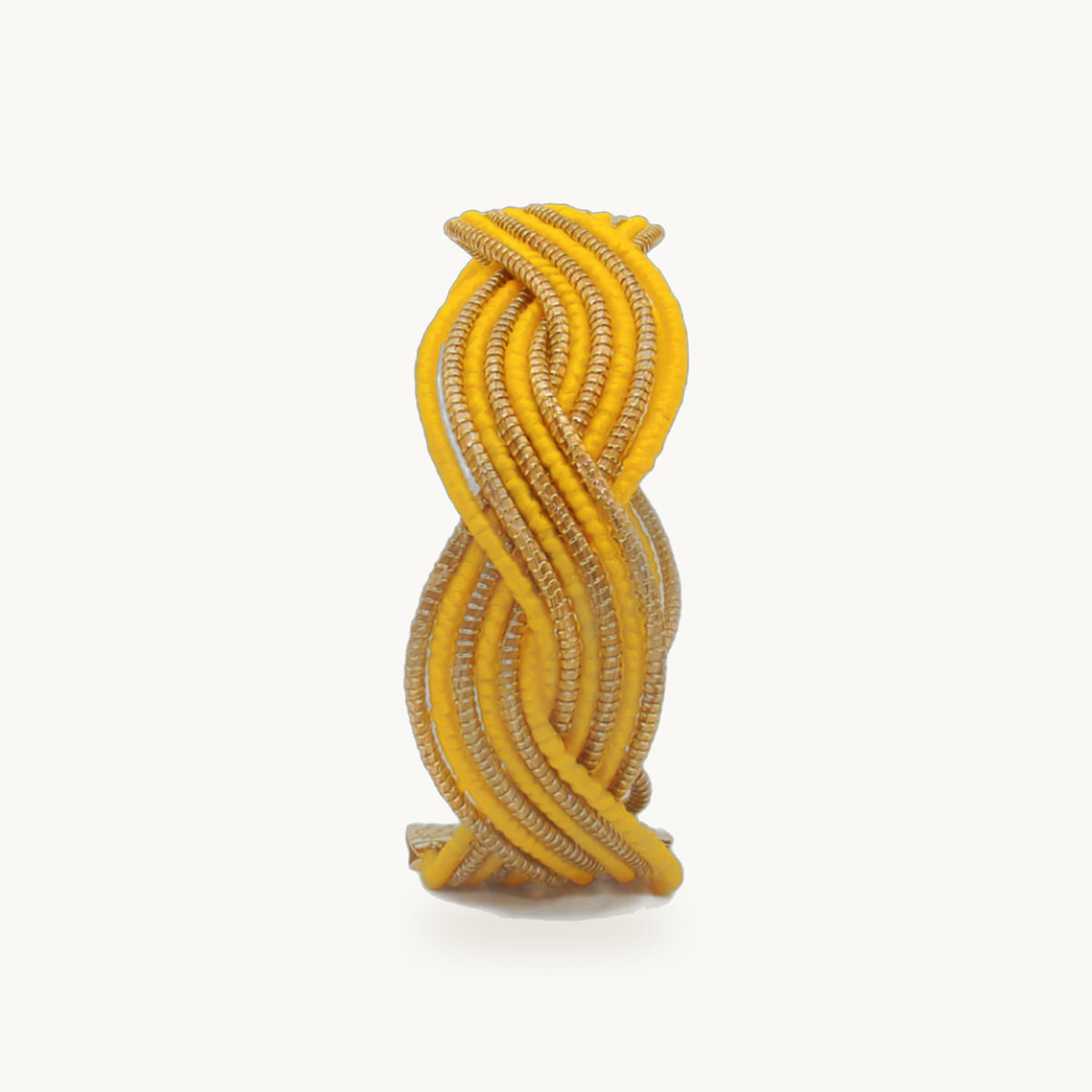 Manchette Caracol ORA alternée jaune, capim dourado tressé main en nœud infini, fond beige