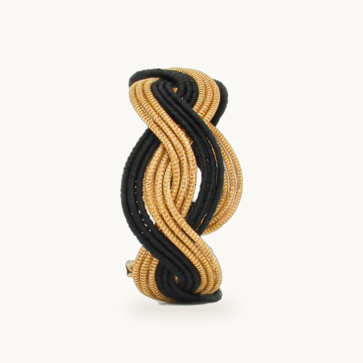 Manchette Caracol ORA bayadère noir, capim dourado tressé main en nœud infini, fond beige
