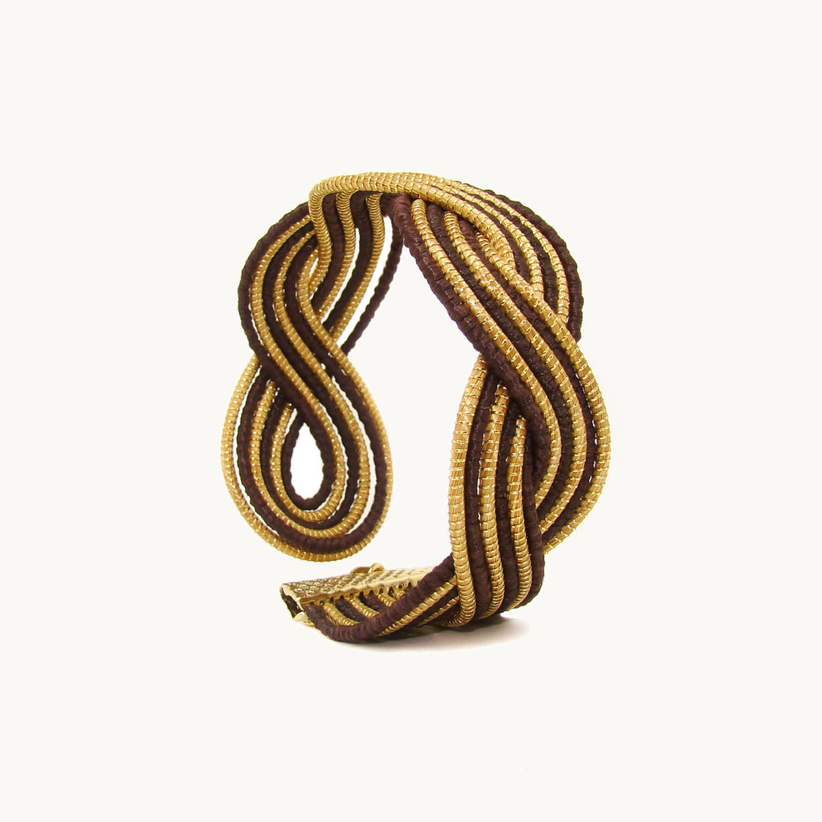 Manchette Caracol ORA vue de trois quarts, nœud en huit et ouverture ajustable, fond beige 