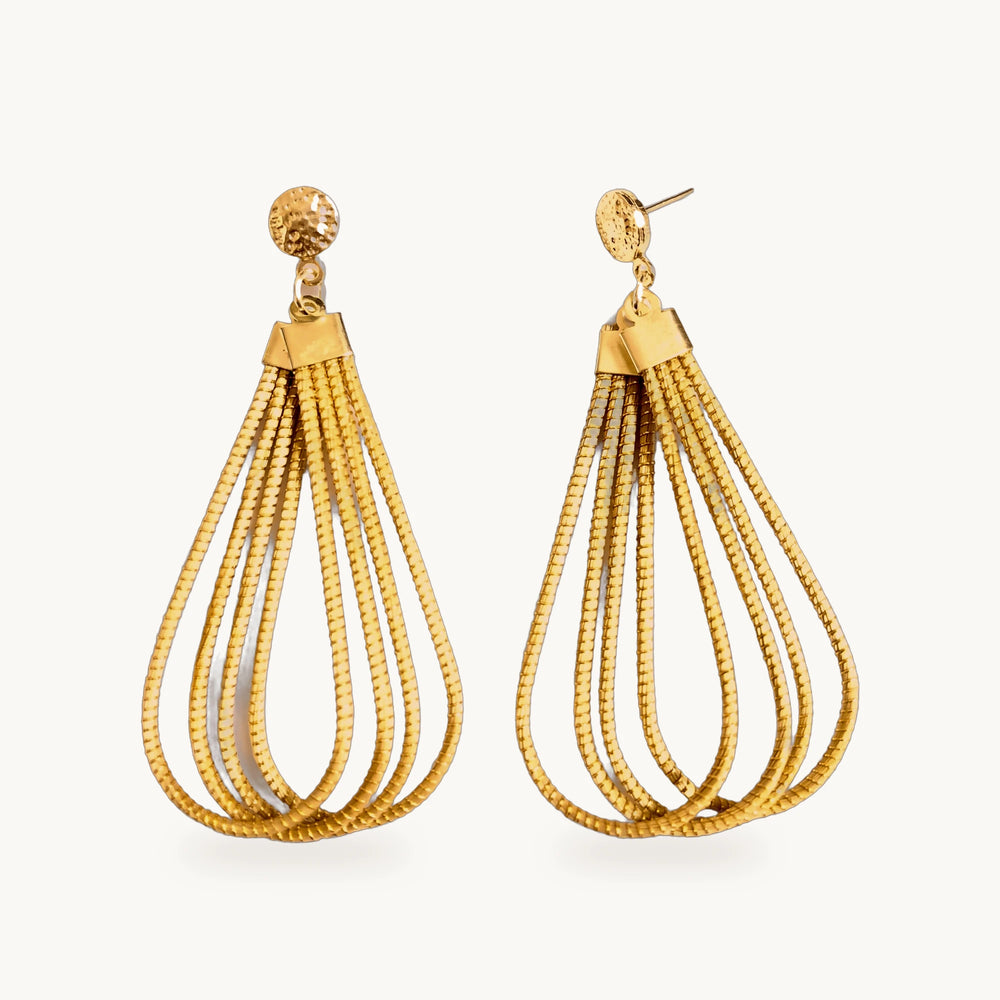 Boucles d'oreilles Gota ORA en forme de goutte, or végétal, sur fond beige