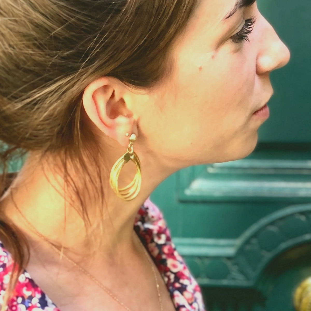 Boucle d'oreille Lola ORA portée, gros plan à l'oreille devant une porte parisienne