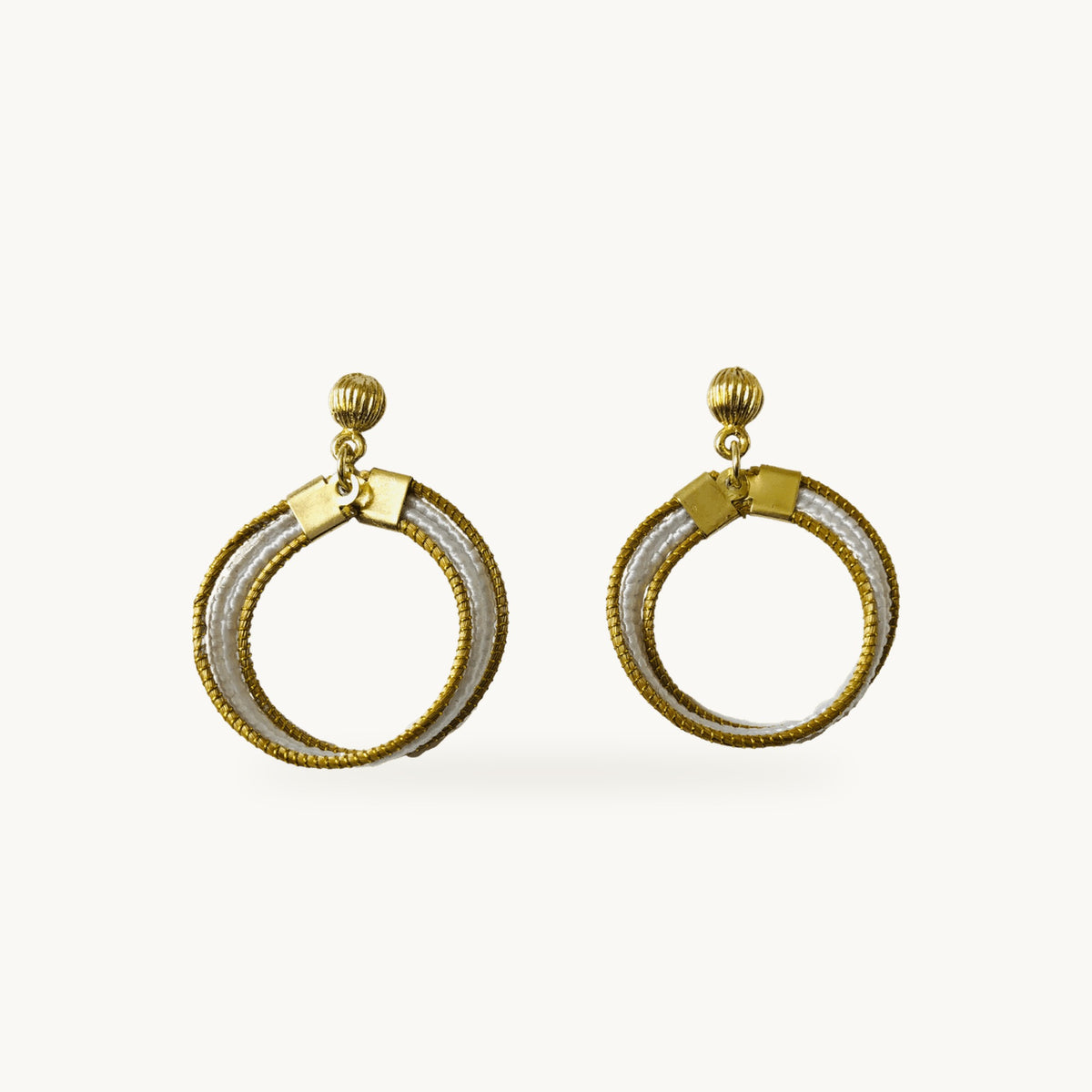 Boucles d'oreilles Lola Arco-Íris ORA blanches, capim dourado tressé main, fond beige