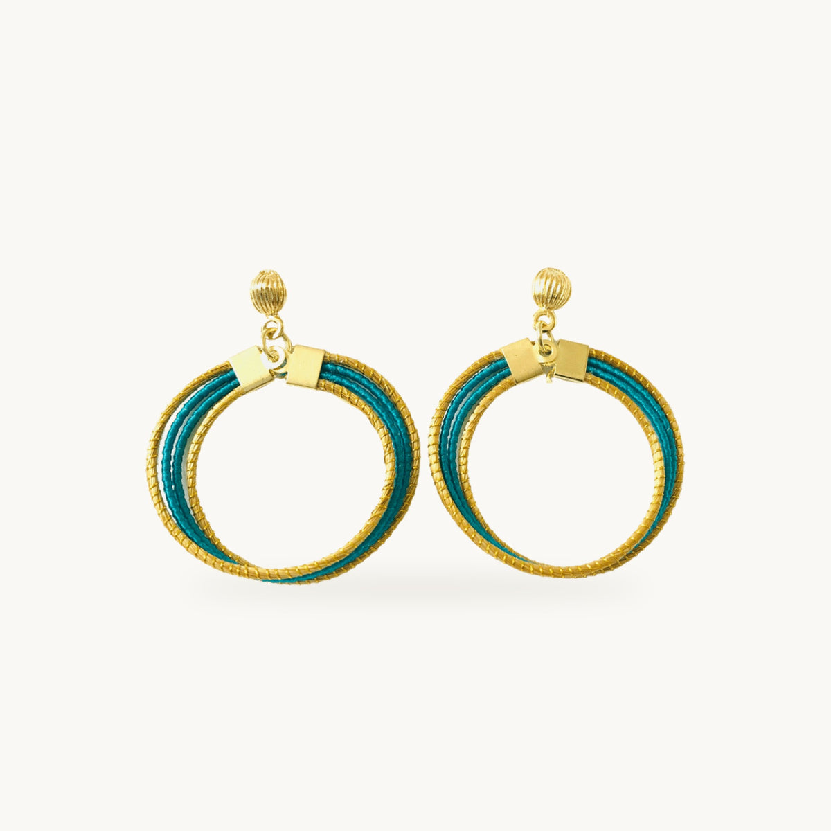 Boucles d'oreilles Lola Arco-Íris ORA turquoise, capim dourado tressé main, fond beige